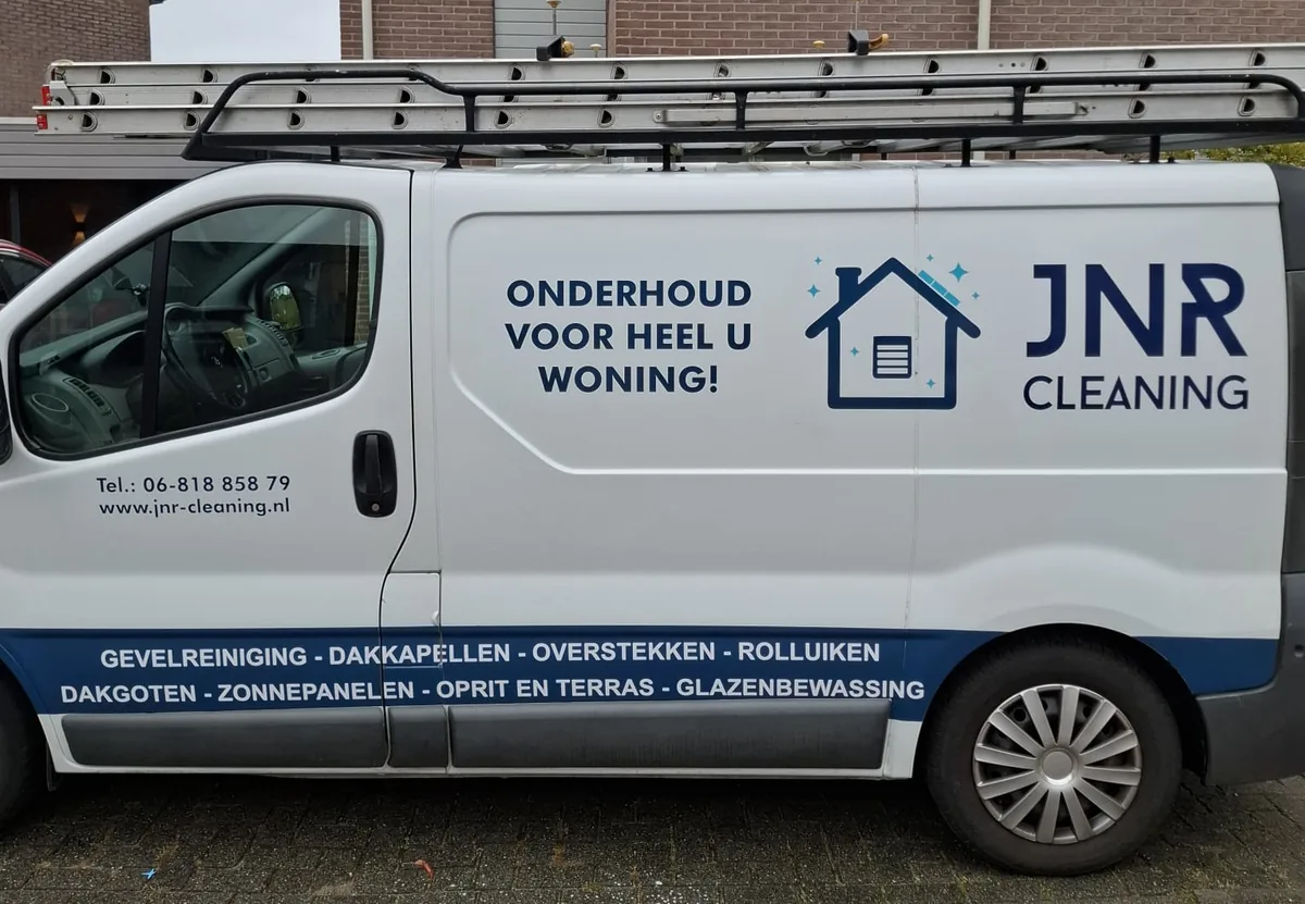 De witte bus van JNR Cleaning met het logo, de diensten en ladders op het dak