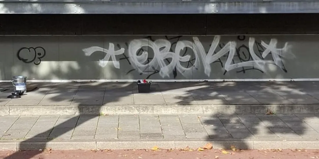 Plint van een appartementengebouw vol graffiti, voor