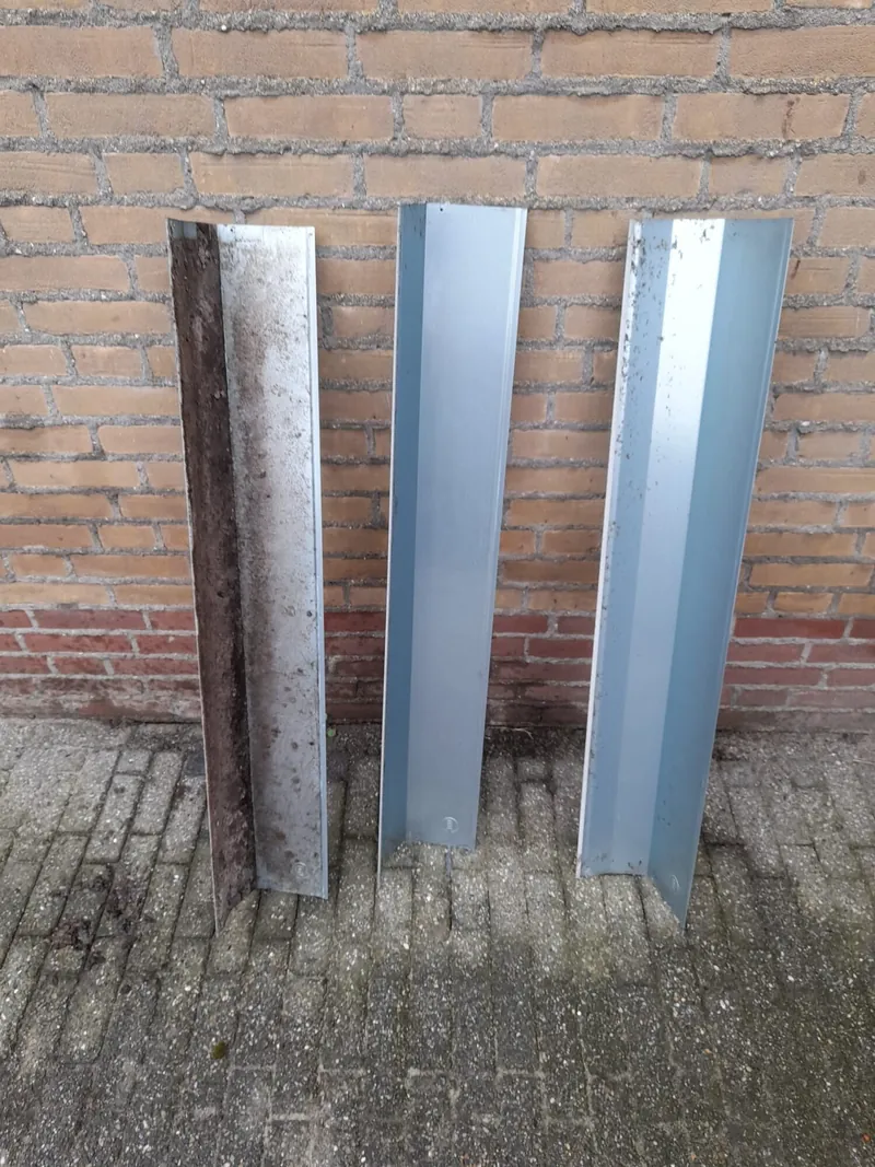 Drie rolluikonderdelen tegen een muur: links nog vuil, rechts twee gereinigd